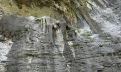 man sieht im Freien der Schlucht Stalagtiten und Stalagmiten, hier ist auch eine Kletterwand